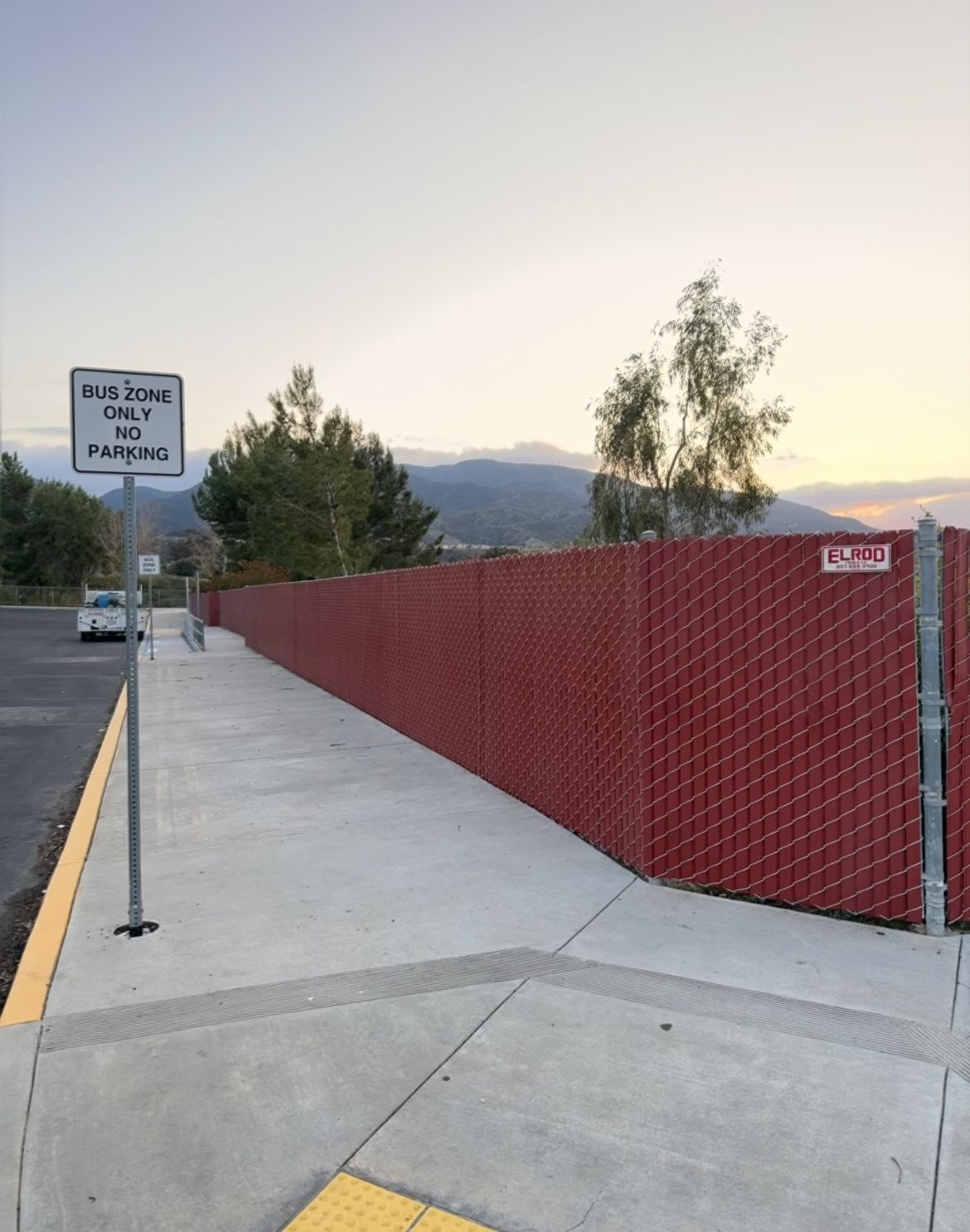A Sidewalk With a Red Fence and a Sign That Says No Parking — Riverside, CA — Elrod Fence Co