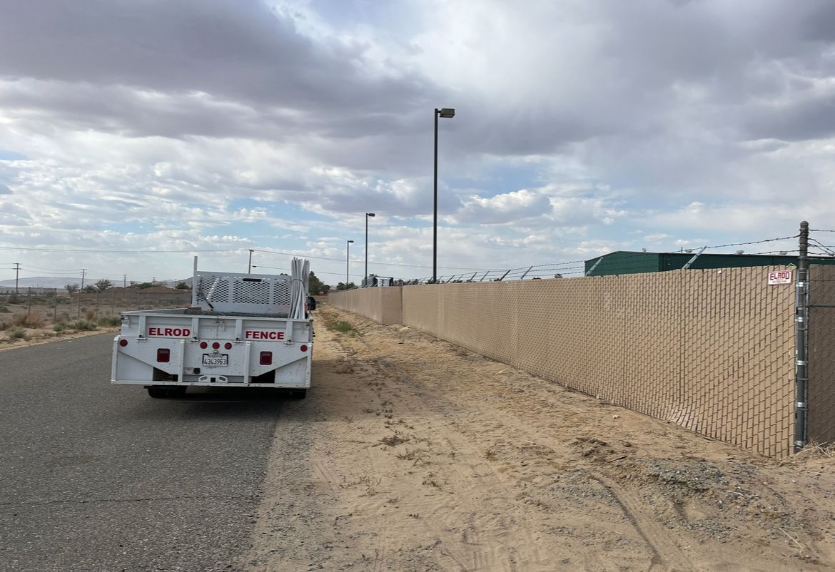 A White Truck Is Parked on the Side of the Road Next to a Fence — Riverside, CA — Elrod Fence Co