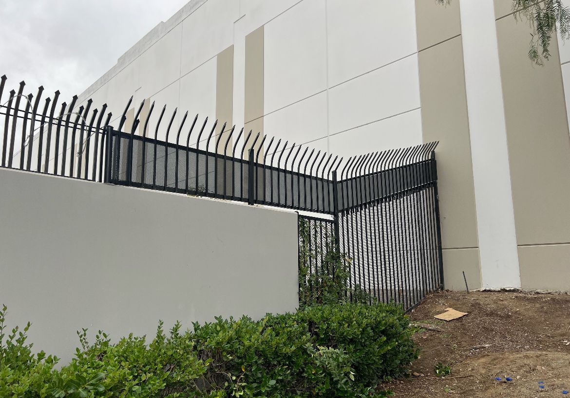 A fence is surrounding a building with graffiti on it.