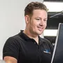 Een man in een zwart shirt kijkt naar een computerscherm.