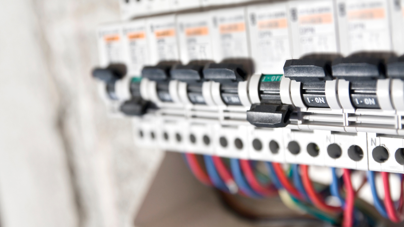 Circuit breaker panel with various colored wires and switches.