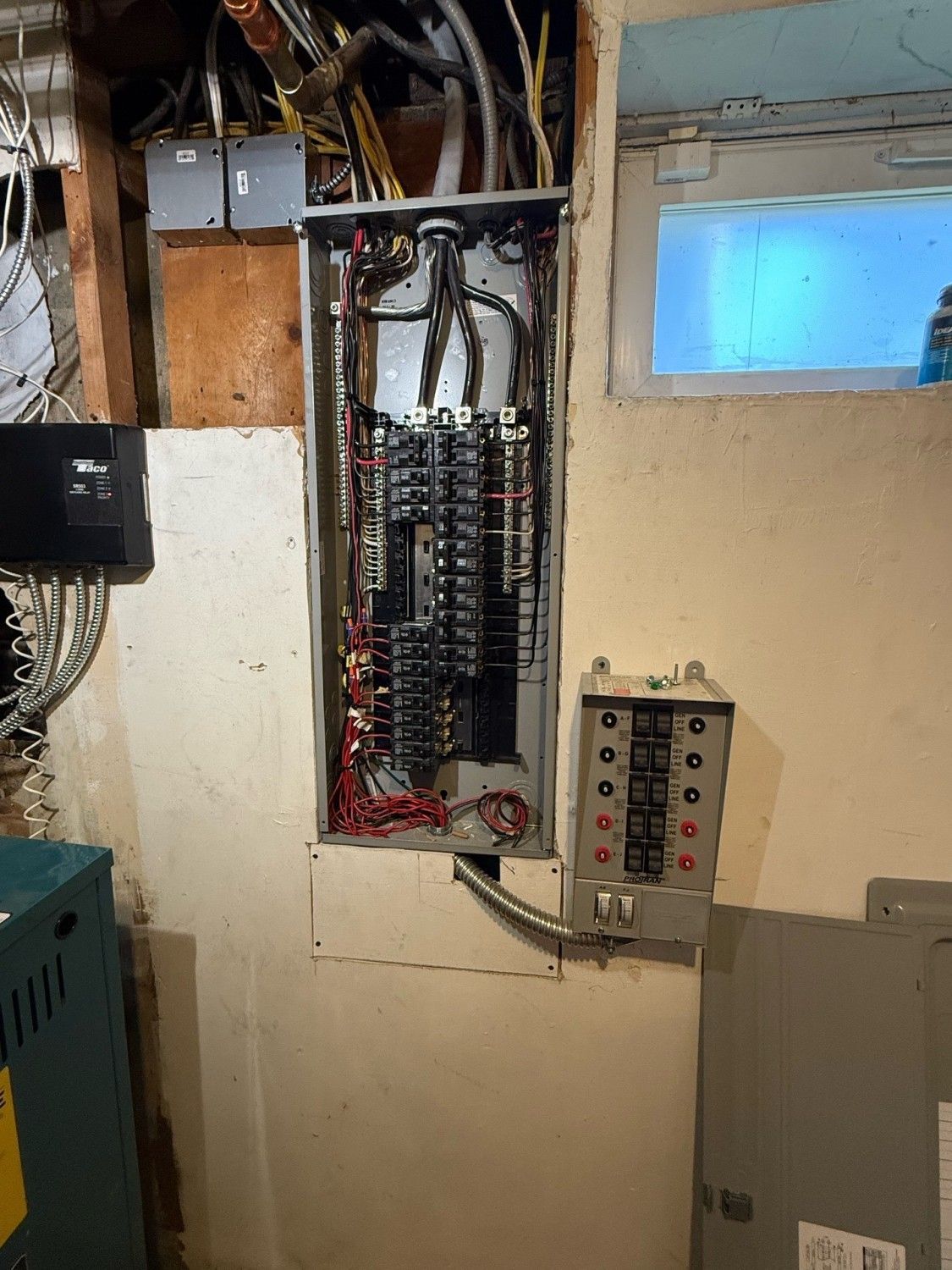Person's hand flipping a circuit breaker switch in a panel with many switches and colored wires.