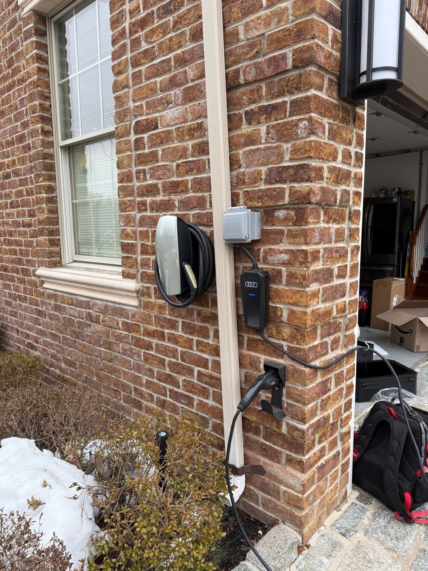 Gray electric car charging at a charging station outdoors.