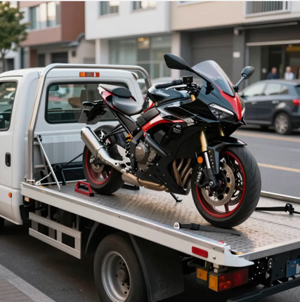 red motorcycle being towed by white tow truck.