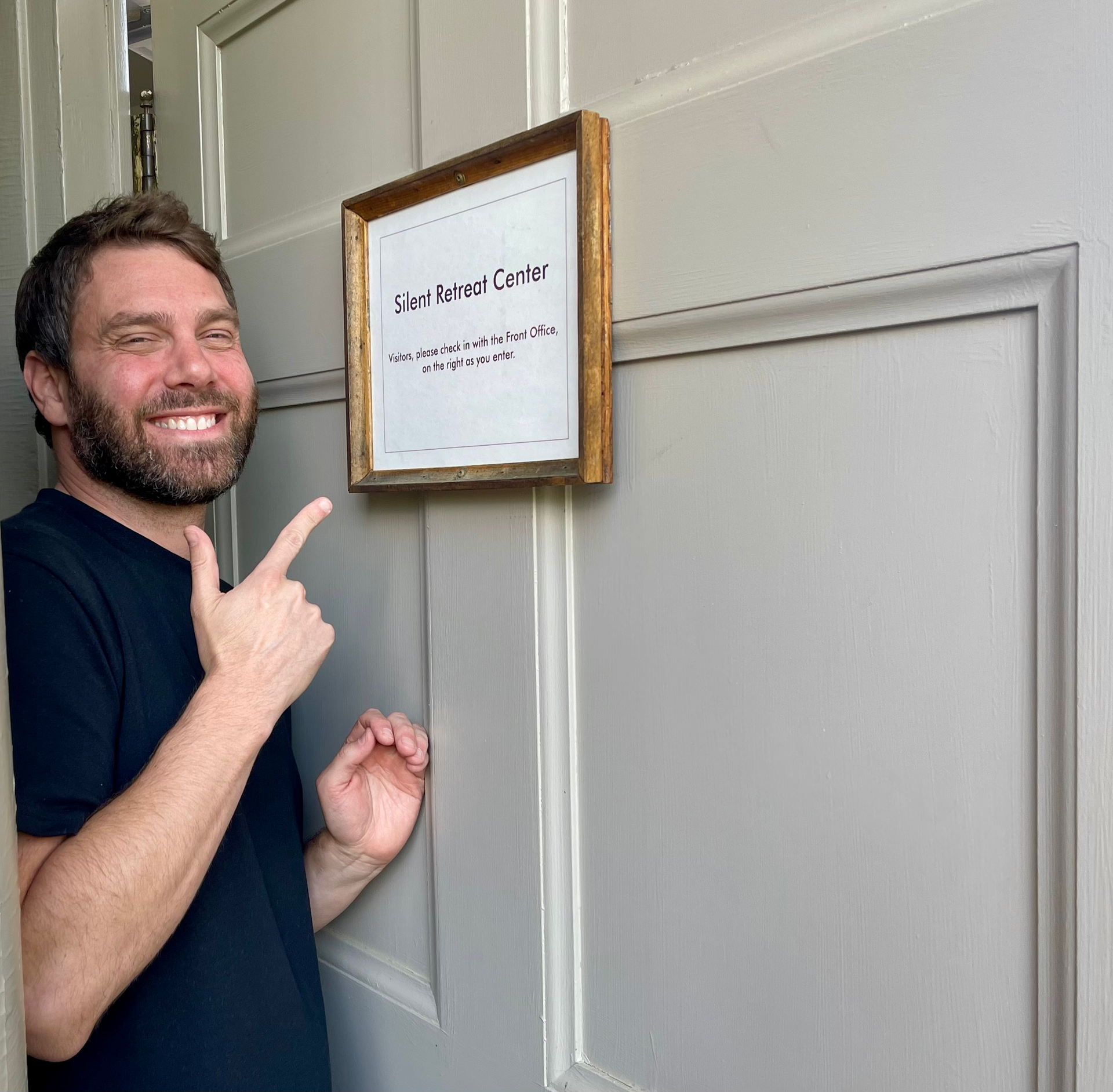 a person looking at a door sign of a silent retreat center