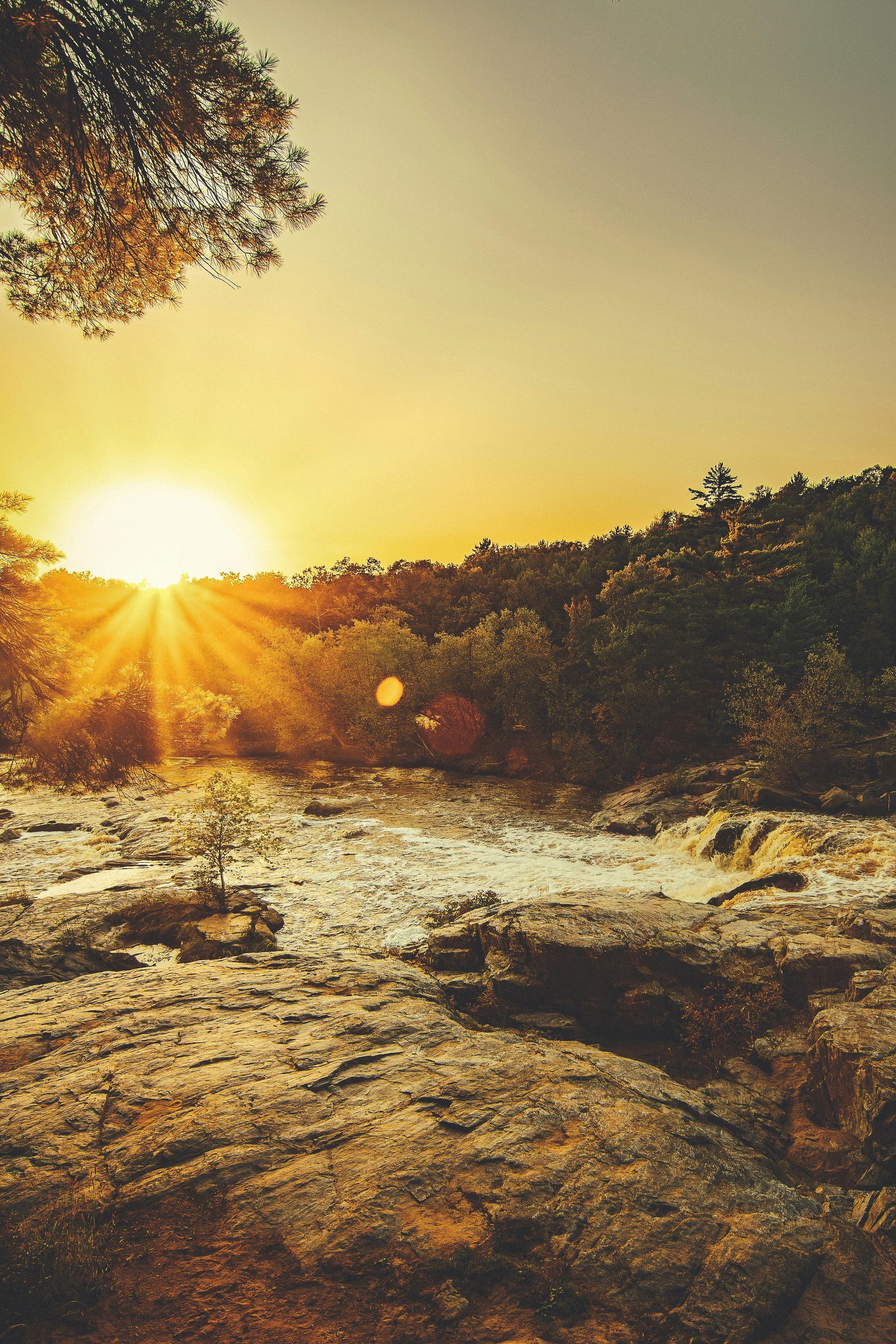 a sunset over water and trees