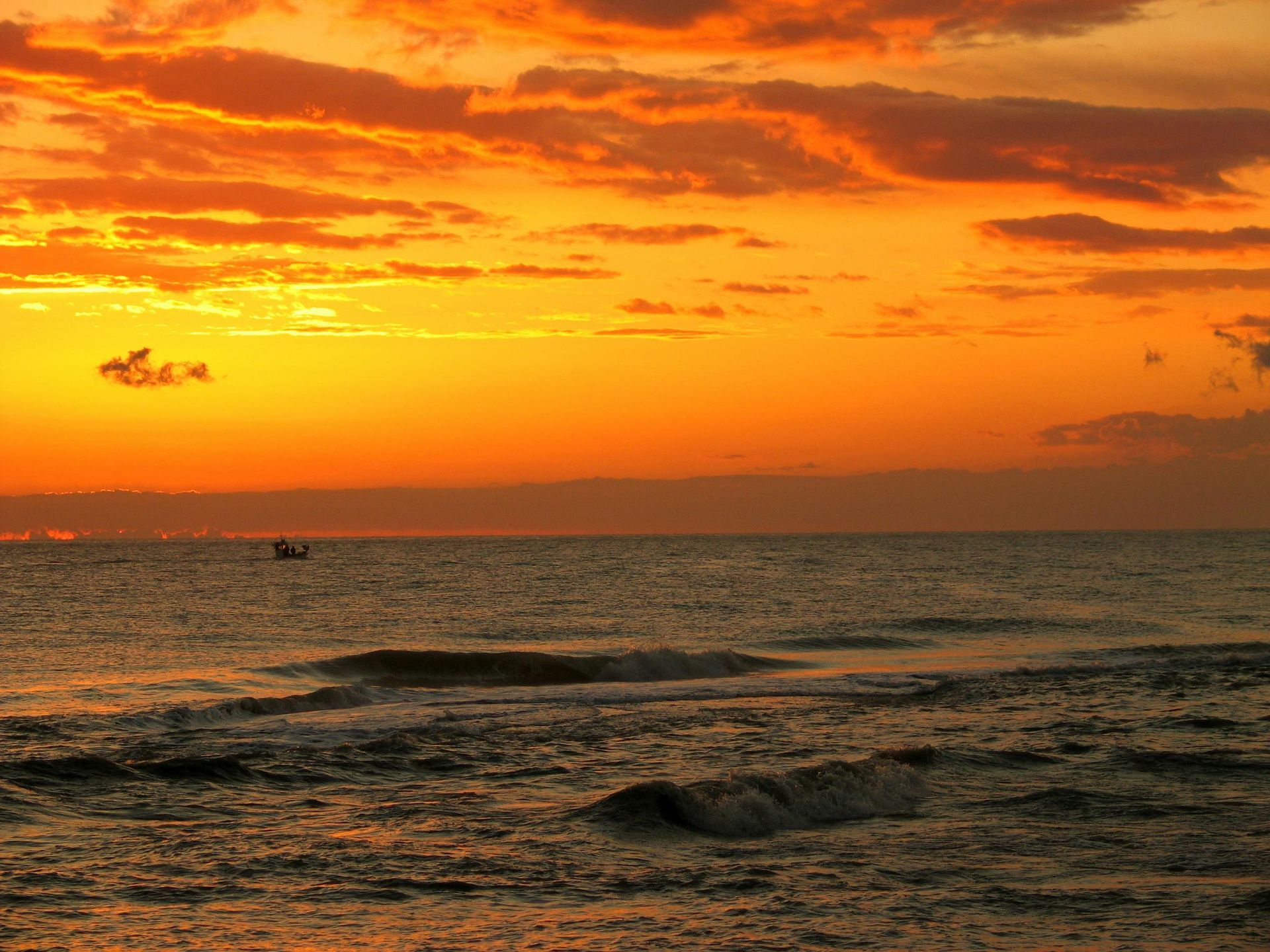 an orange sky over an ocean