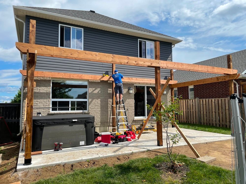 A man is standing on a ladder in front of a house.