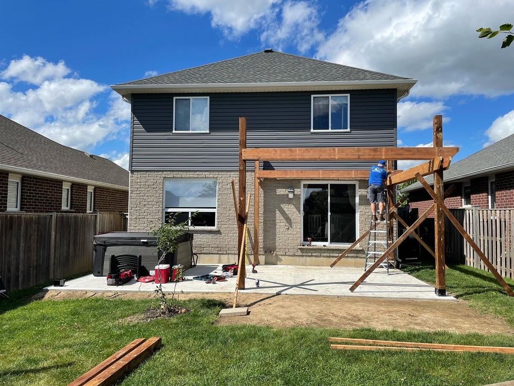 A man is standing on a ladder in front of a house.