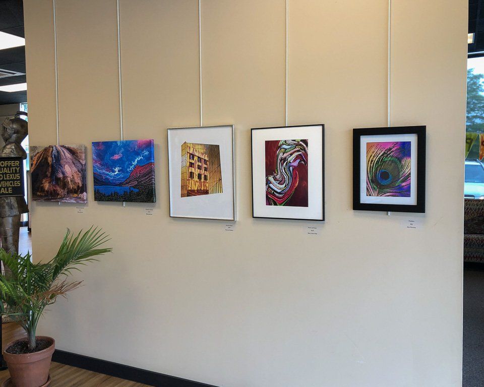 A row of paintings hanging on a wall in a room.