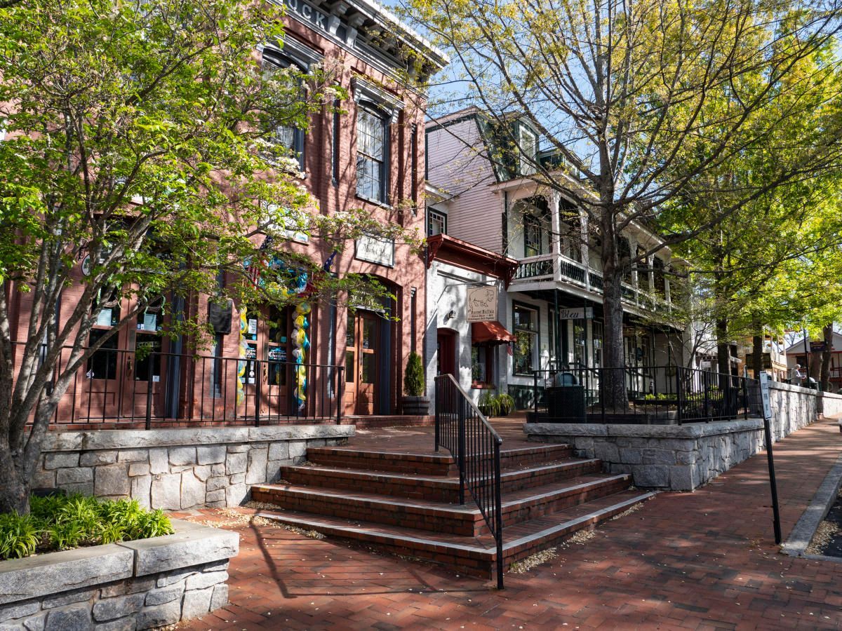 A row of brick buildings with stairs leading up to them in a small town.