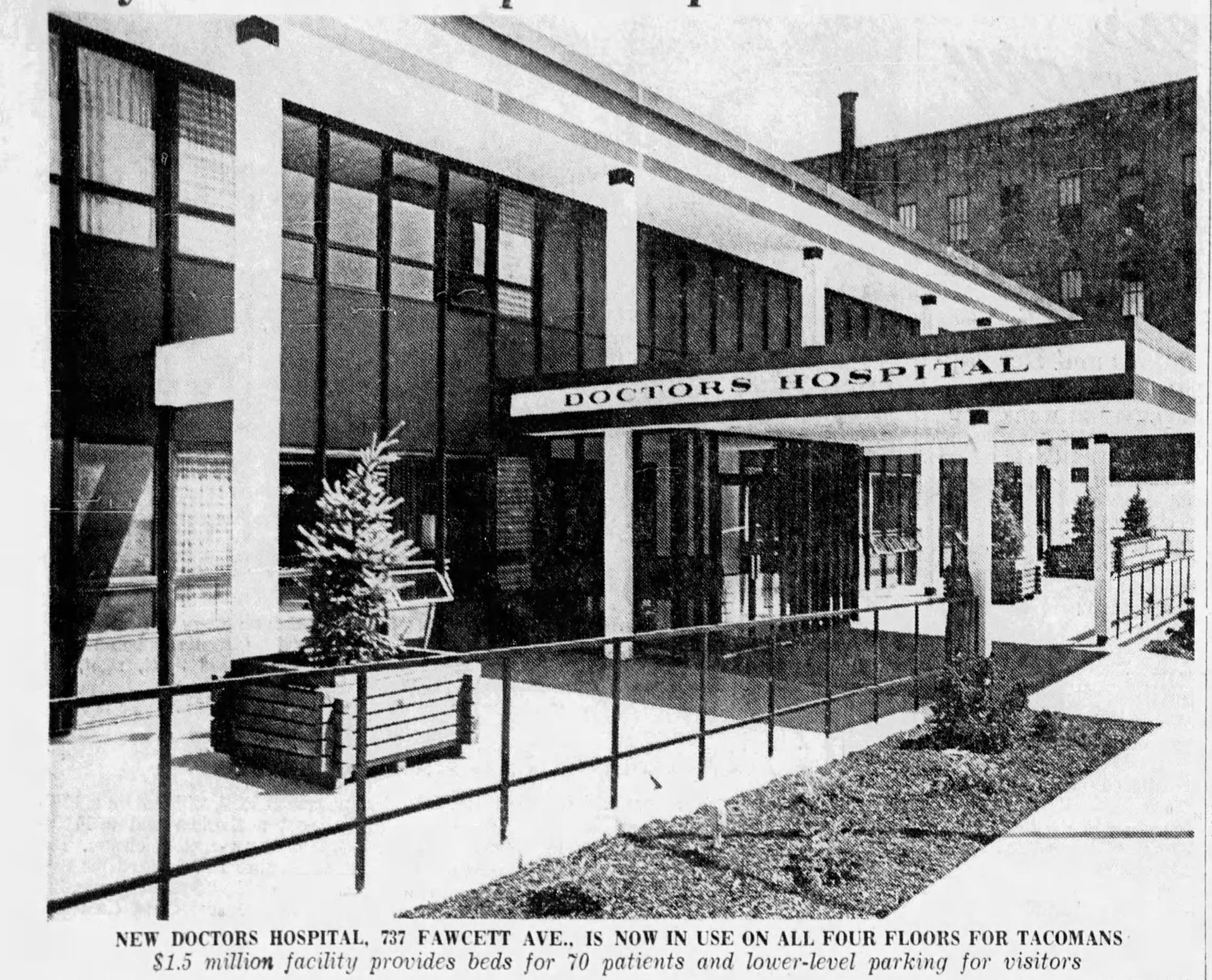 Doctors Hospital entrance with glass windows, a canopy, and signage on a sunny day.