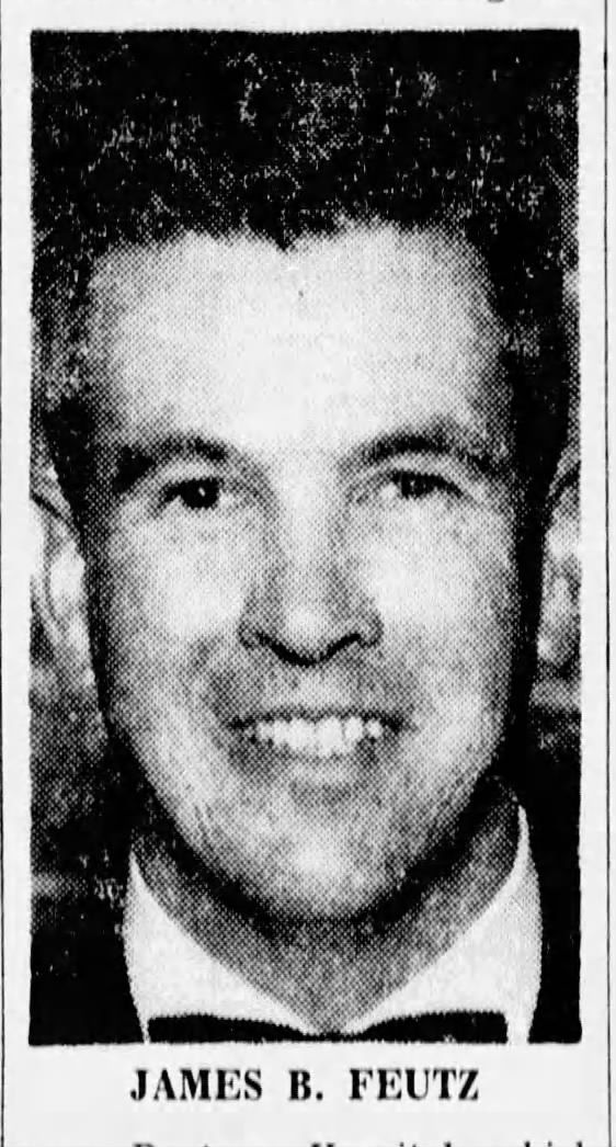 James B. Feutz portrait, smiling, dark hair, wearing a suit.