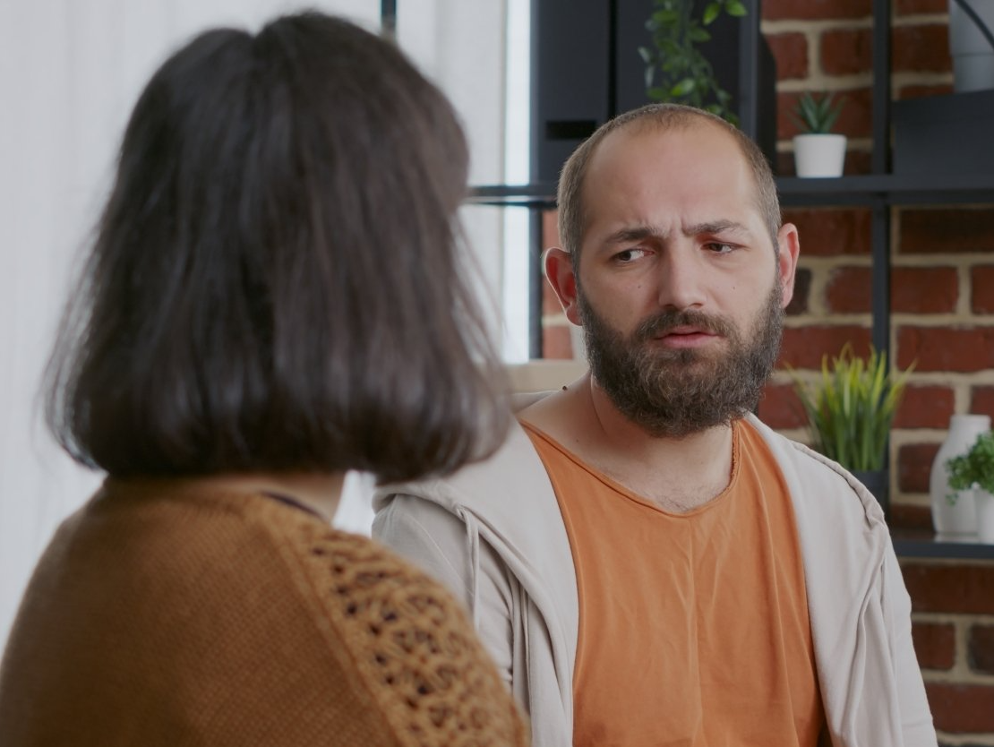 Man looking at a person with a concerned expression.