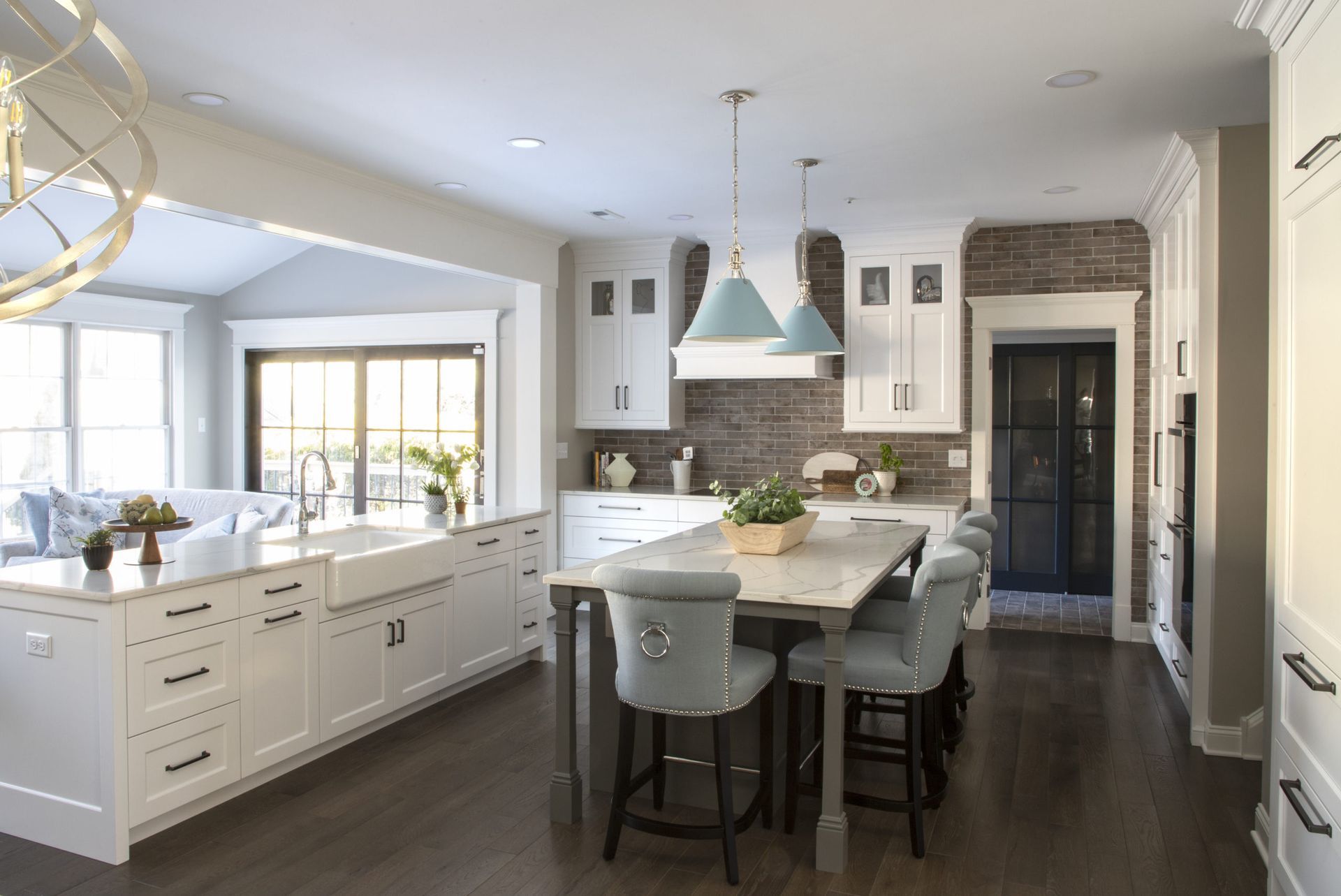 A kitchen with white cabinets and a large island in the middle.