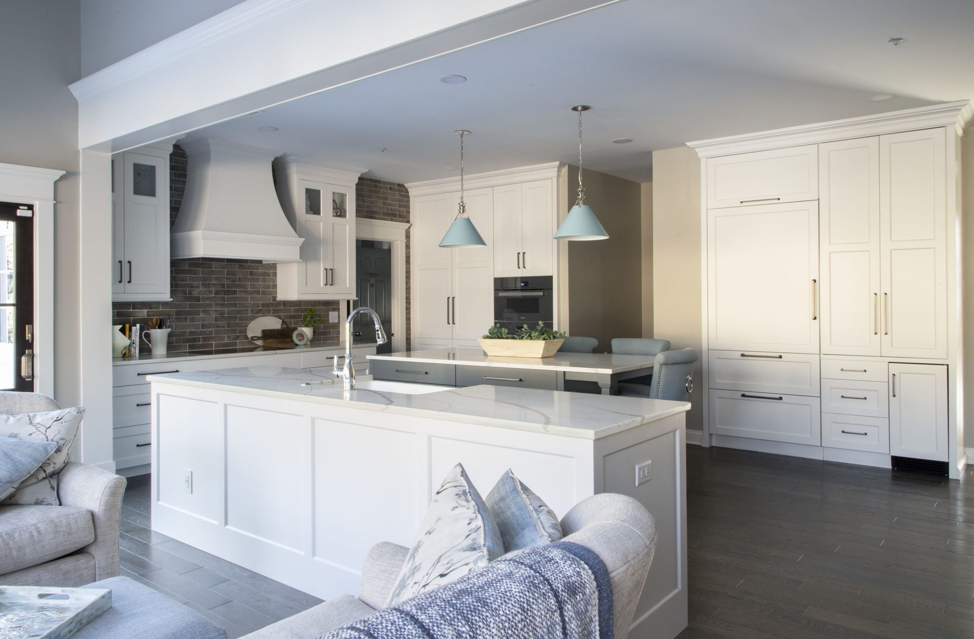 A kitchen with white cabinets and a large island in the middle of the room.