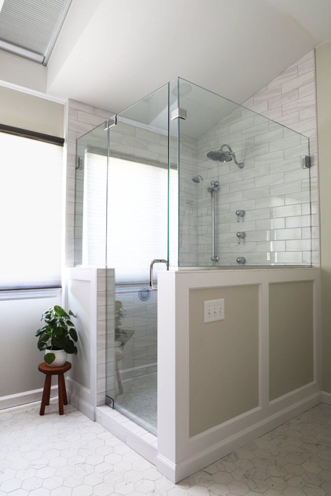 A bathroom with a walk in shower with a glass door.