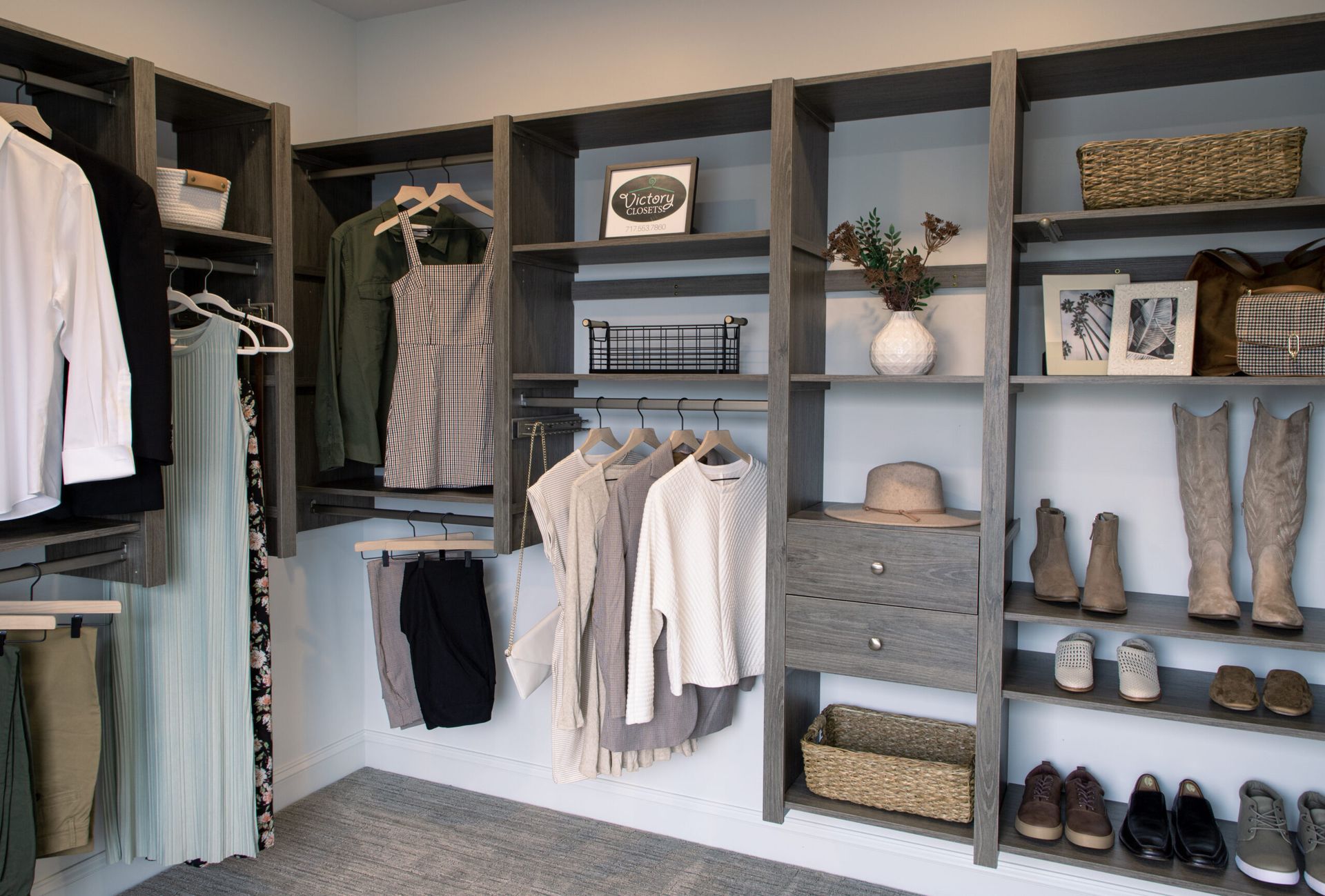 Gray closet with hanging clothes, shelves, and shoes.