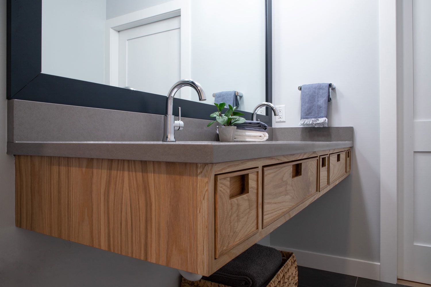 A bathroom with a sink , mirror and drawers.