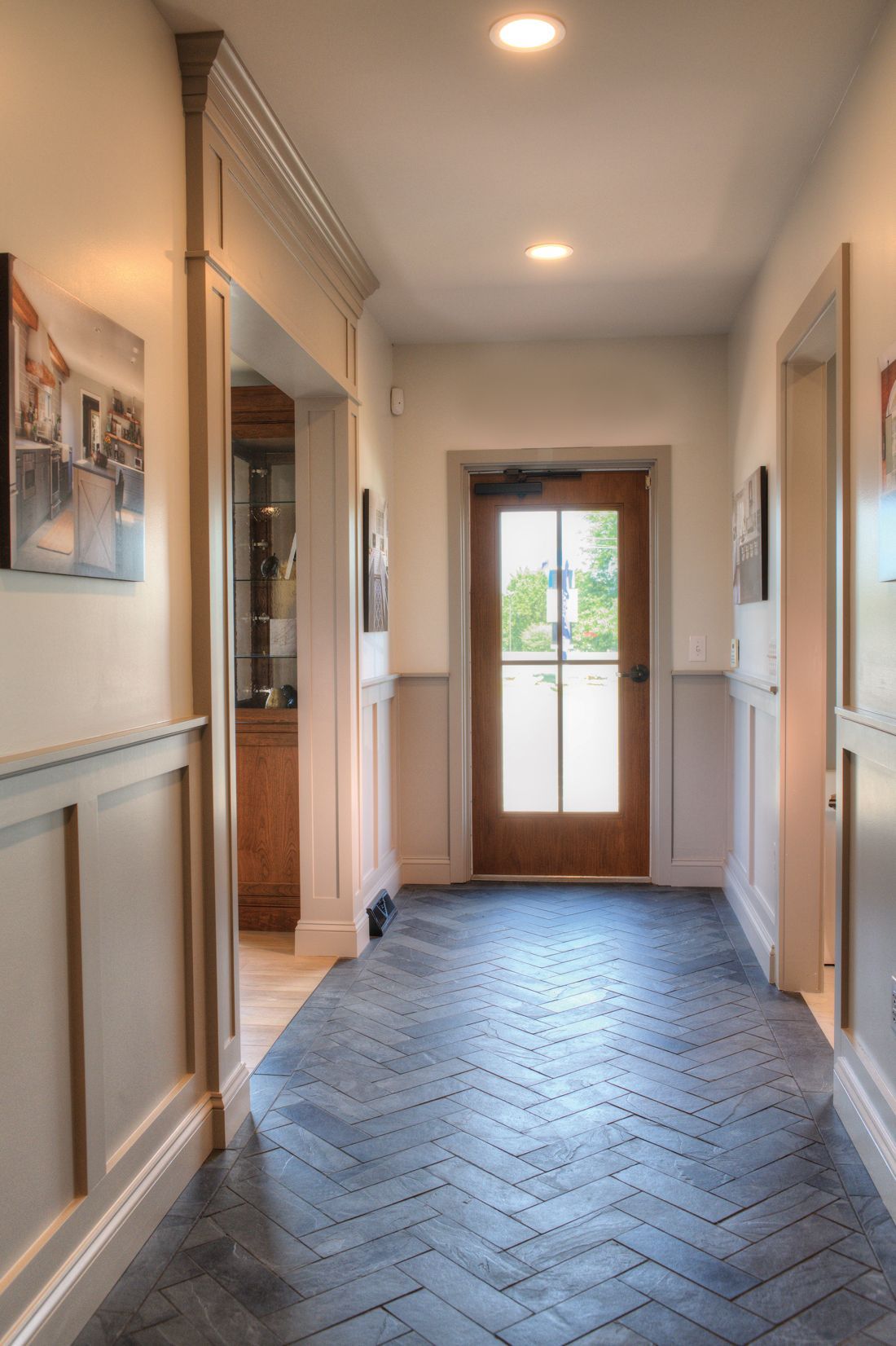 A hallway with a brick floor and a wooden door