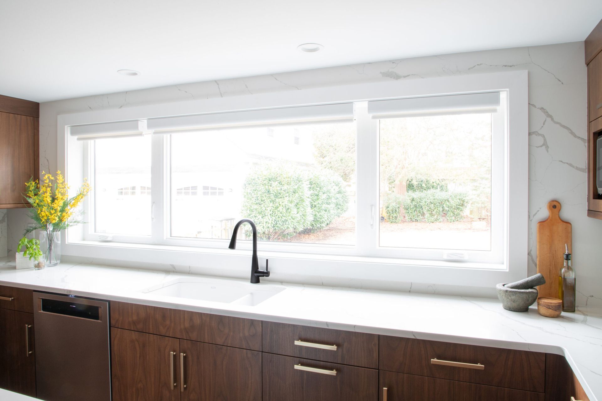 A kitchen with a sink and a large window.