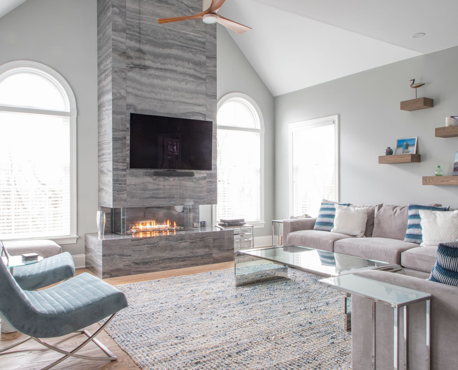 A living room with a fireplace , couch , chair and television.