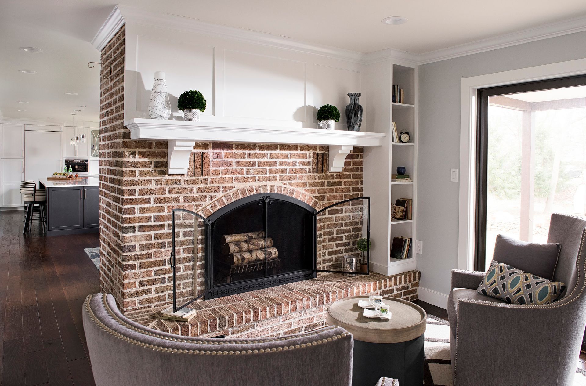 A living room with a brick fireplace and chairs