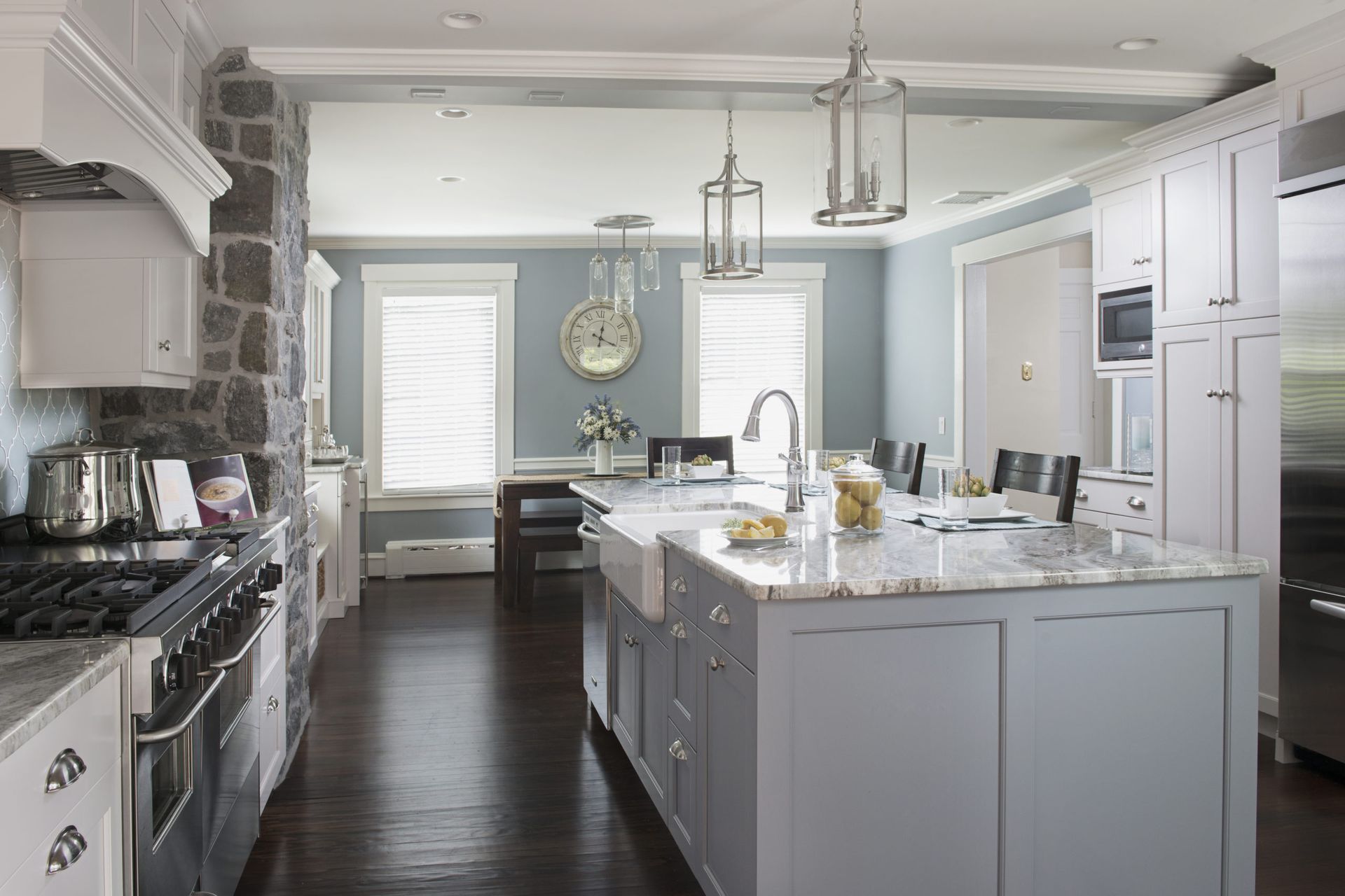 A kitchen with a large island in the middle and a clock on the wall.
