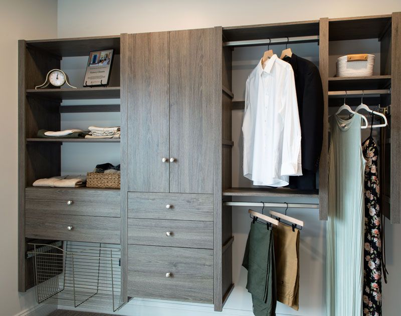 A walk in closet with clothes hanging on racks and shelves