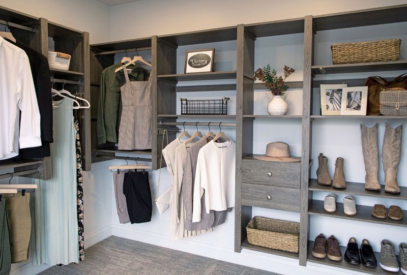 A walk in custom closet system filled with clothes and shoes by KBE in Lancaster PA.