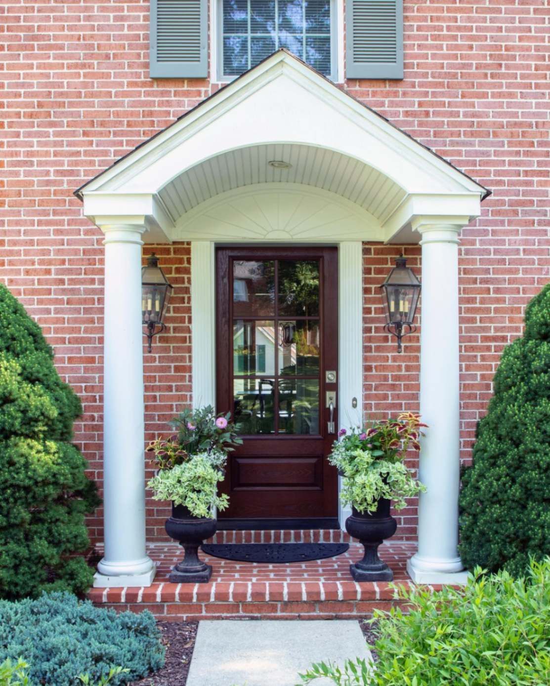 A brick house with a porch and planters in front of it in Lancaster PA