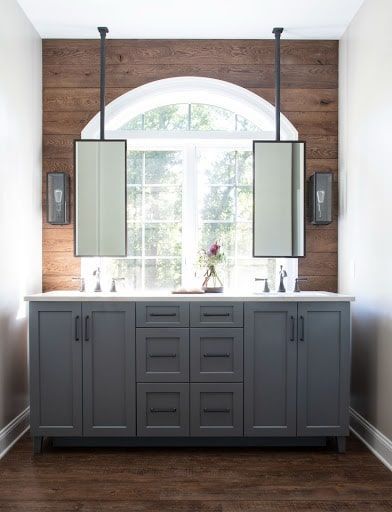A remodeled bathroom in Lancaster PA with two sinks and two mirrors hanging from the ceiling.
