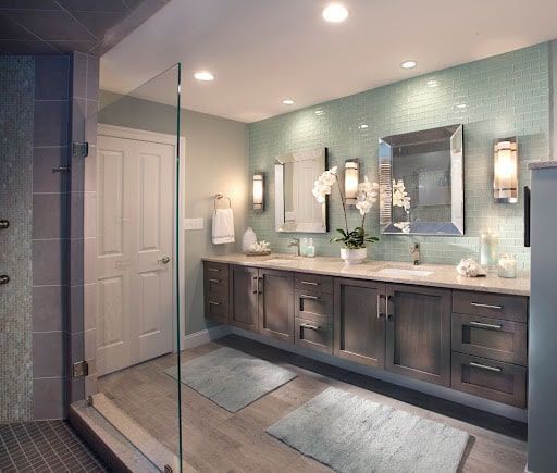 Modern bathroom with gray cabinets, a mint green accent wall, and glass shower.