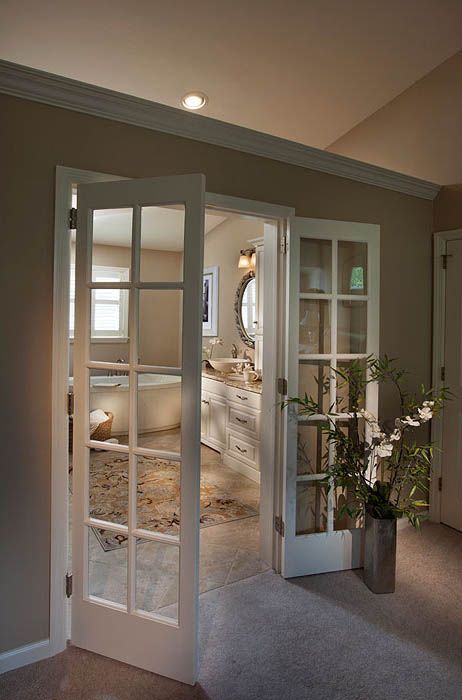 French doors open to a bathroom with a tub