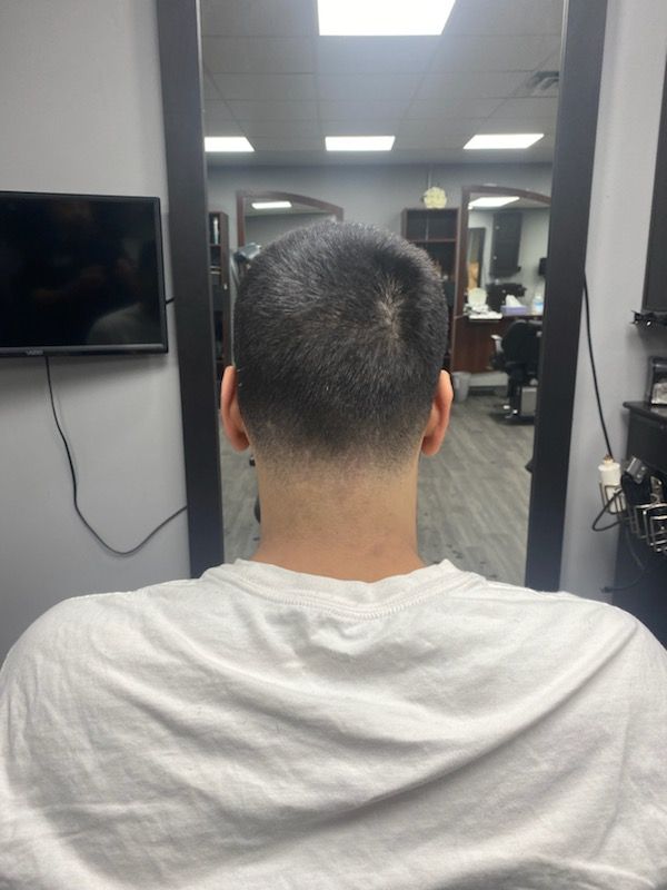 A man is getting his hair cut at a barber shop