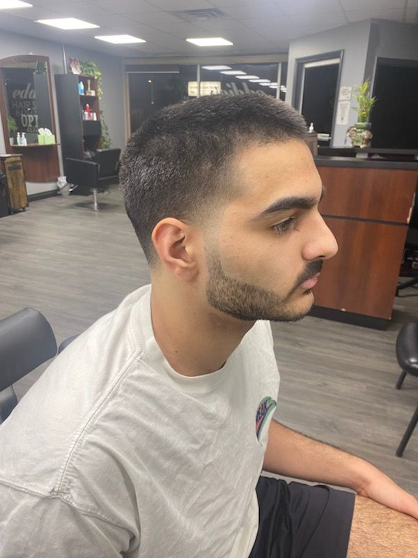 A man with a beard is sitting in a chair in a salon.