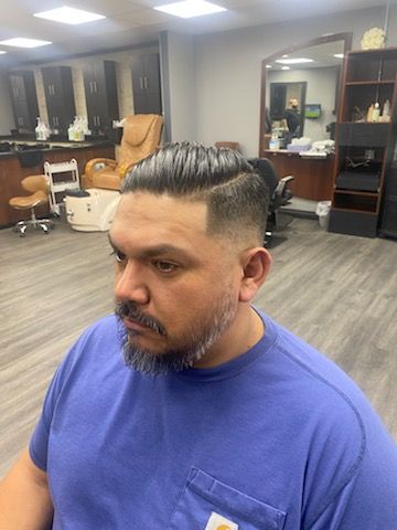 A man with a beard is getting his hair cut at a barber shop.