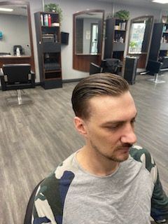 A man is sitting in a chair in a hair salon.