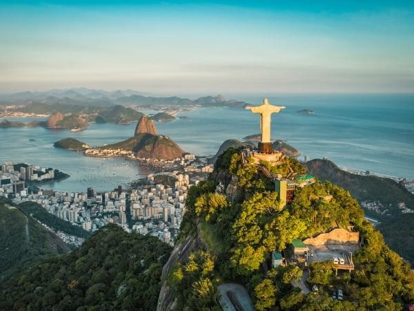 Vista aerea della statua del Cristo Redentore che domina Rio de Janeiro, Brasile, con il monte Pan di Zucchero sullo sfondo.