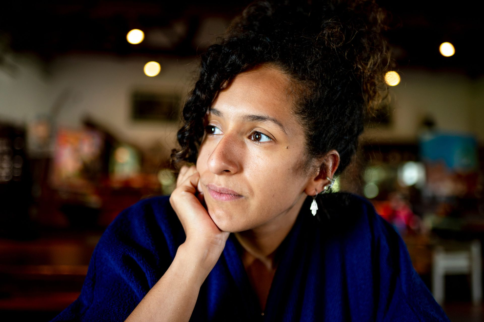 A woman in a deep thought with hands on her chin.