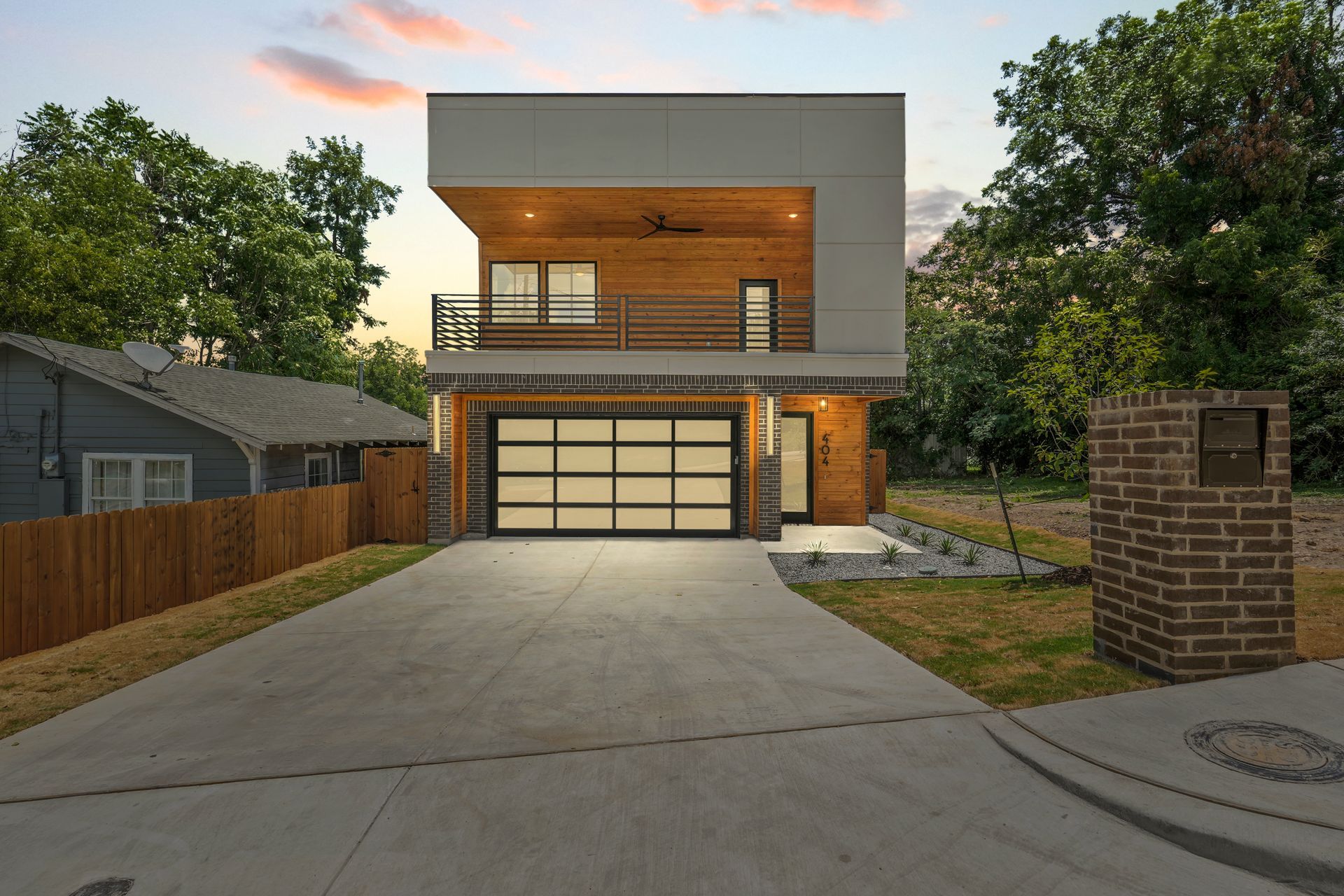 A modern two-story house with a spacious driveway and a sleek garage door.