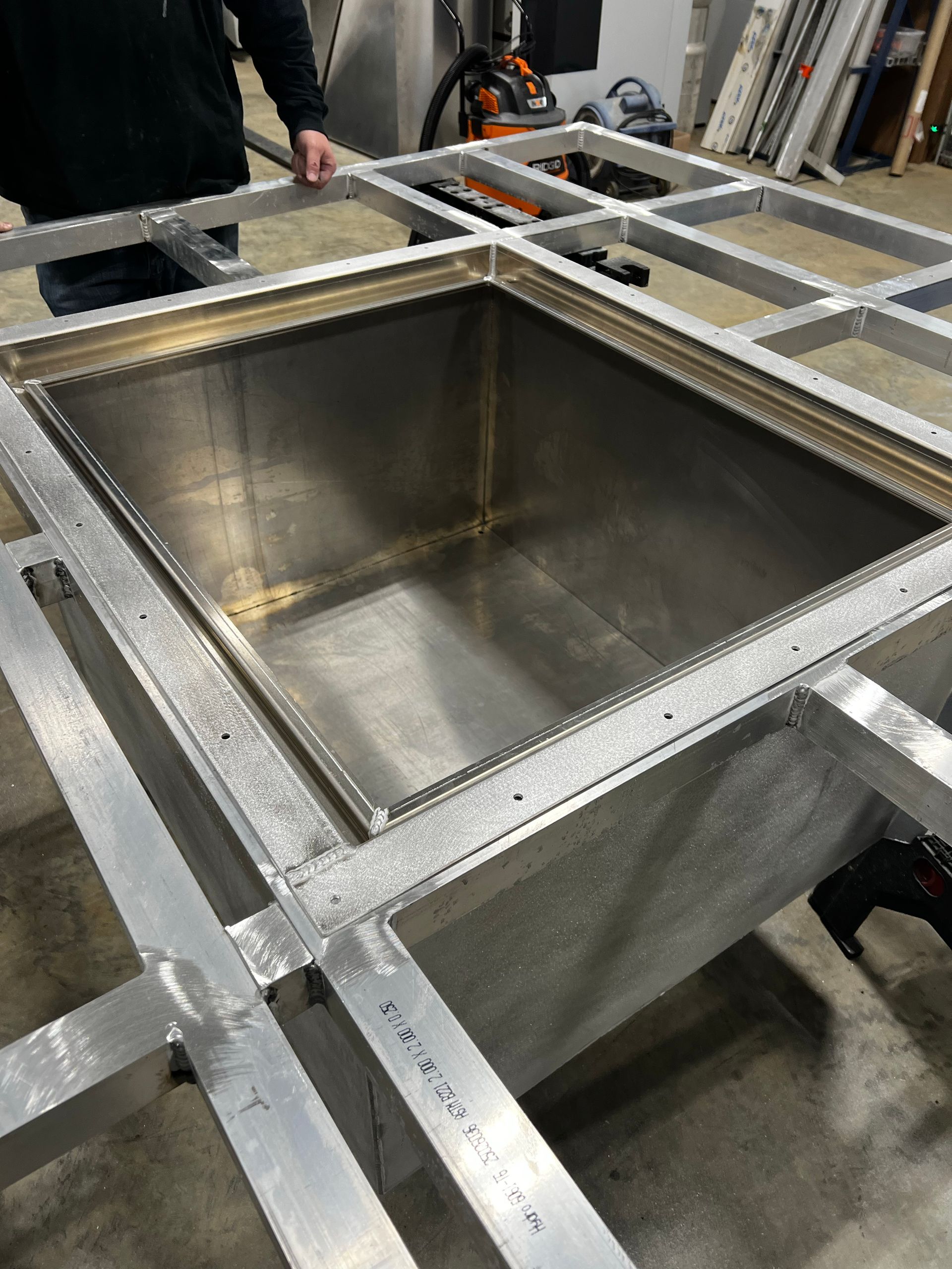 A stainless steel container is sitting on top of a metal frame.