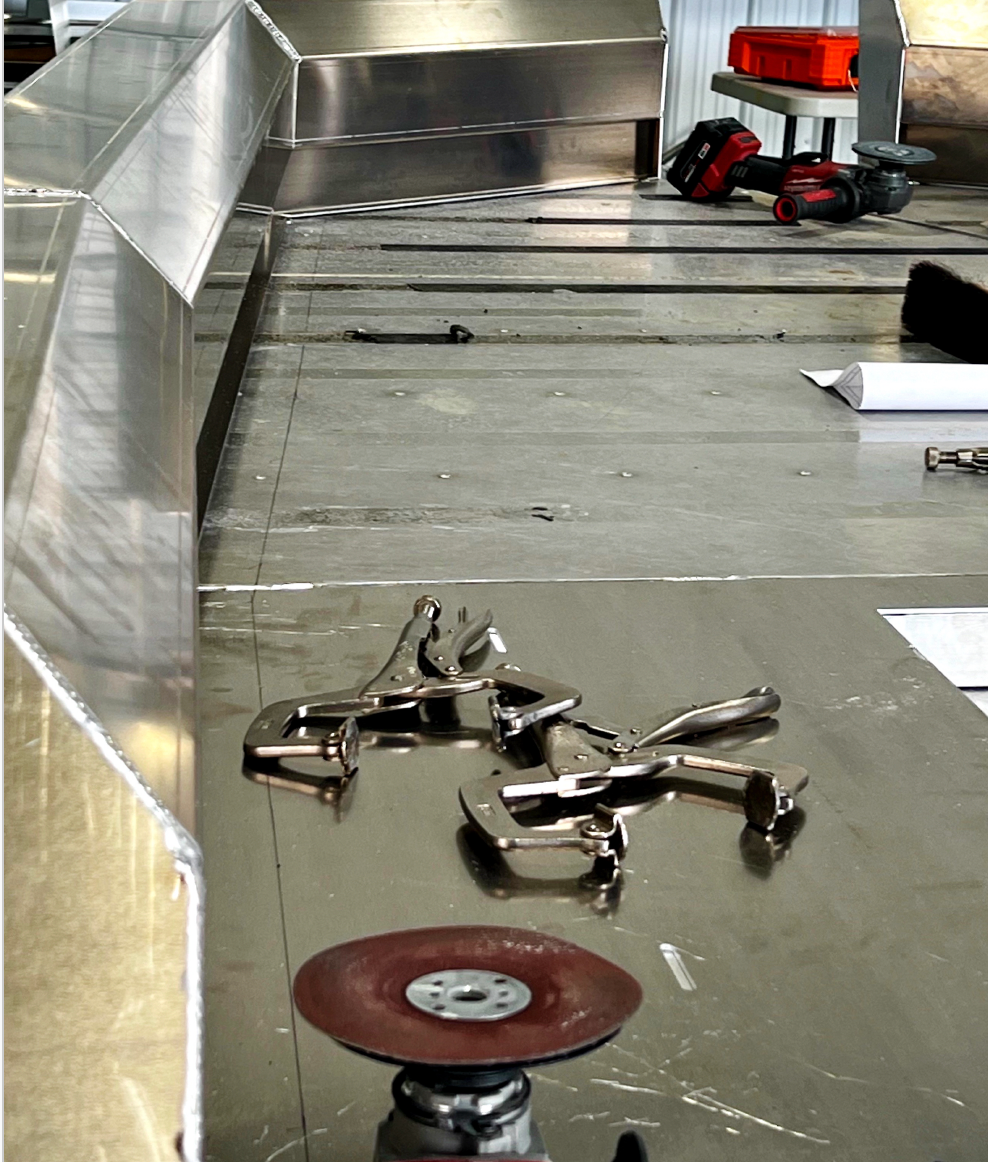 Tools are laying on the floor of a metal boat.