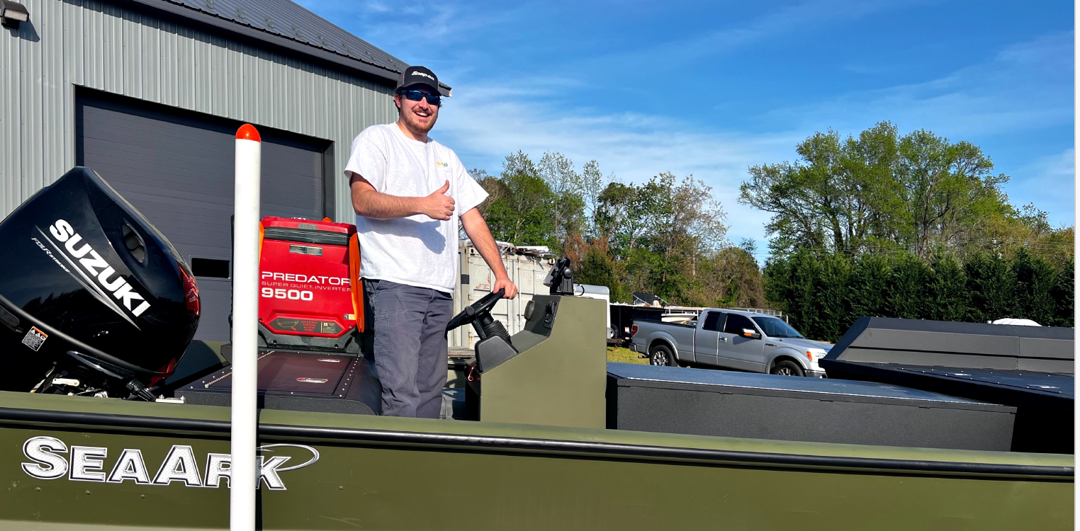 A man is standing in his boat on a trailer.