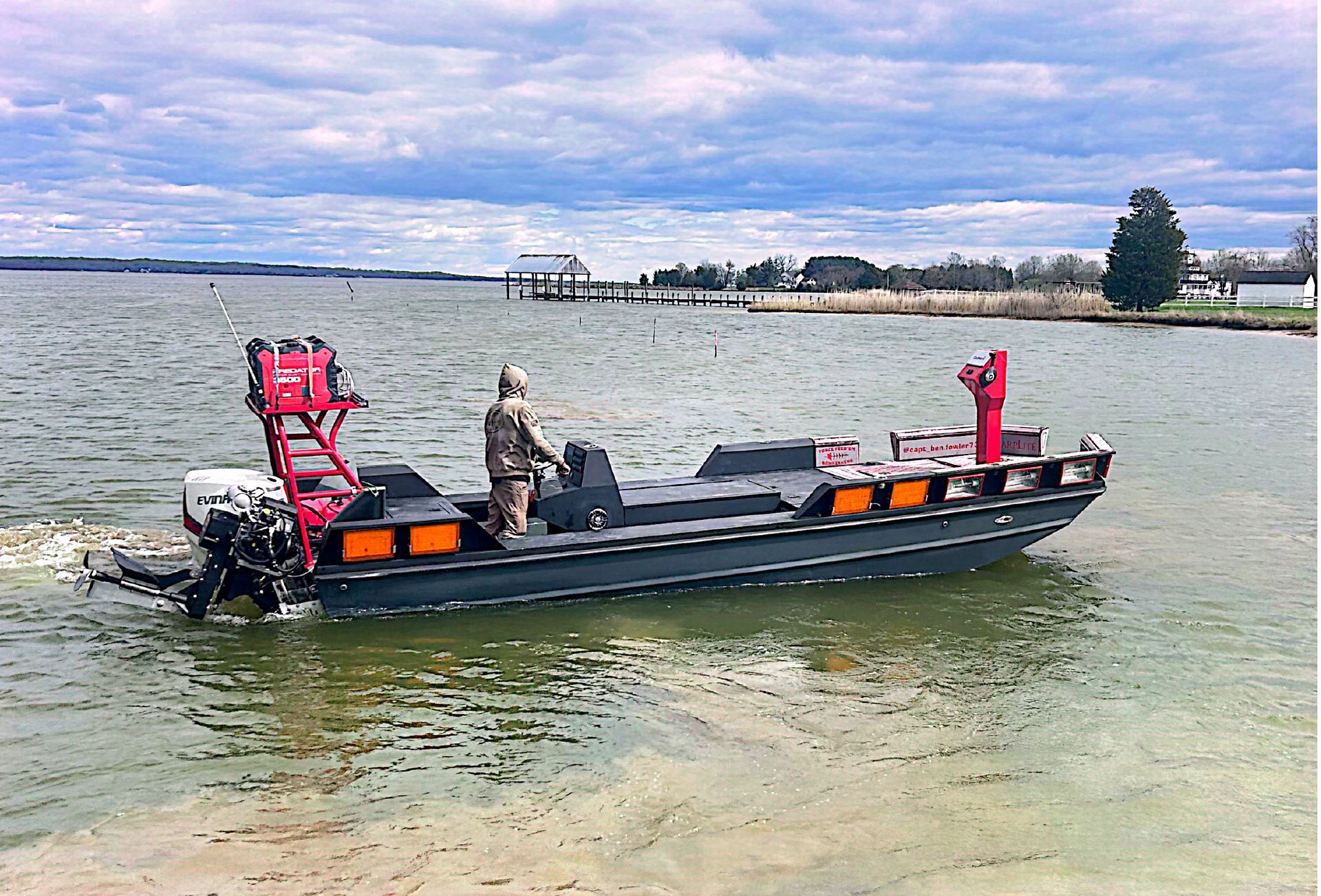 Blake's invader boat on the water with men bow fishing.