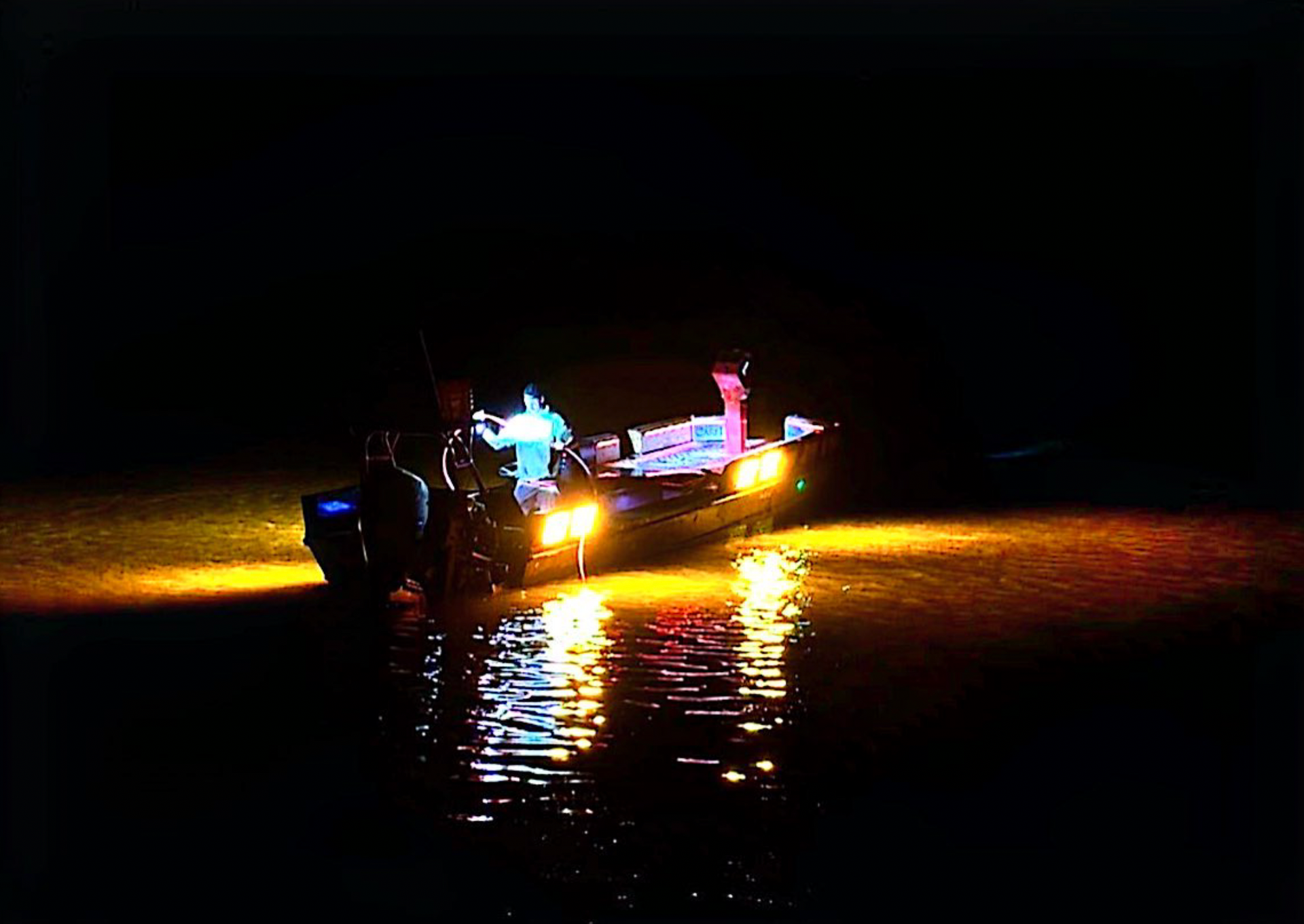 Blake's invader boat on the water at night.