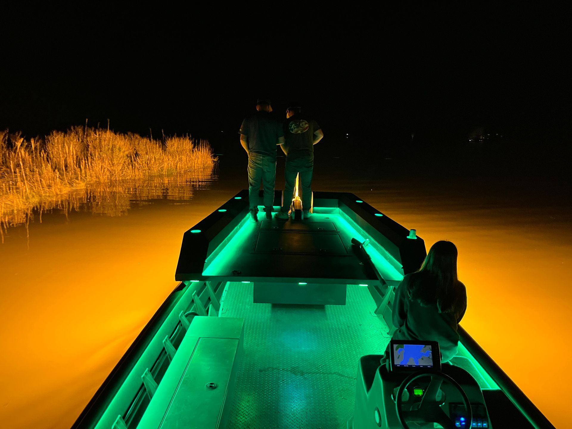 bow hunting boat on the water at night with lights