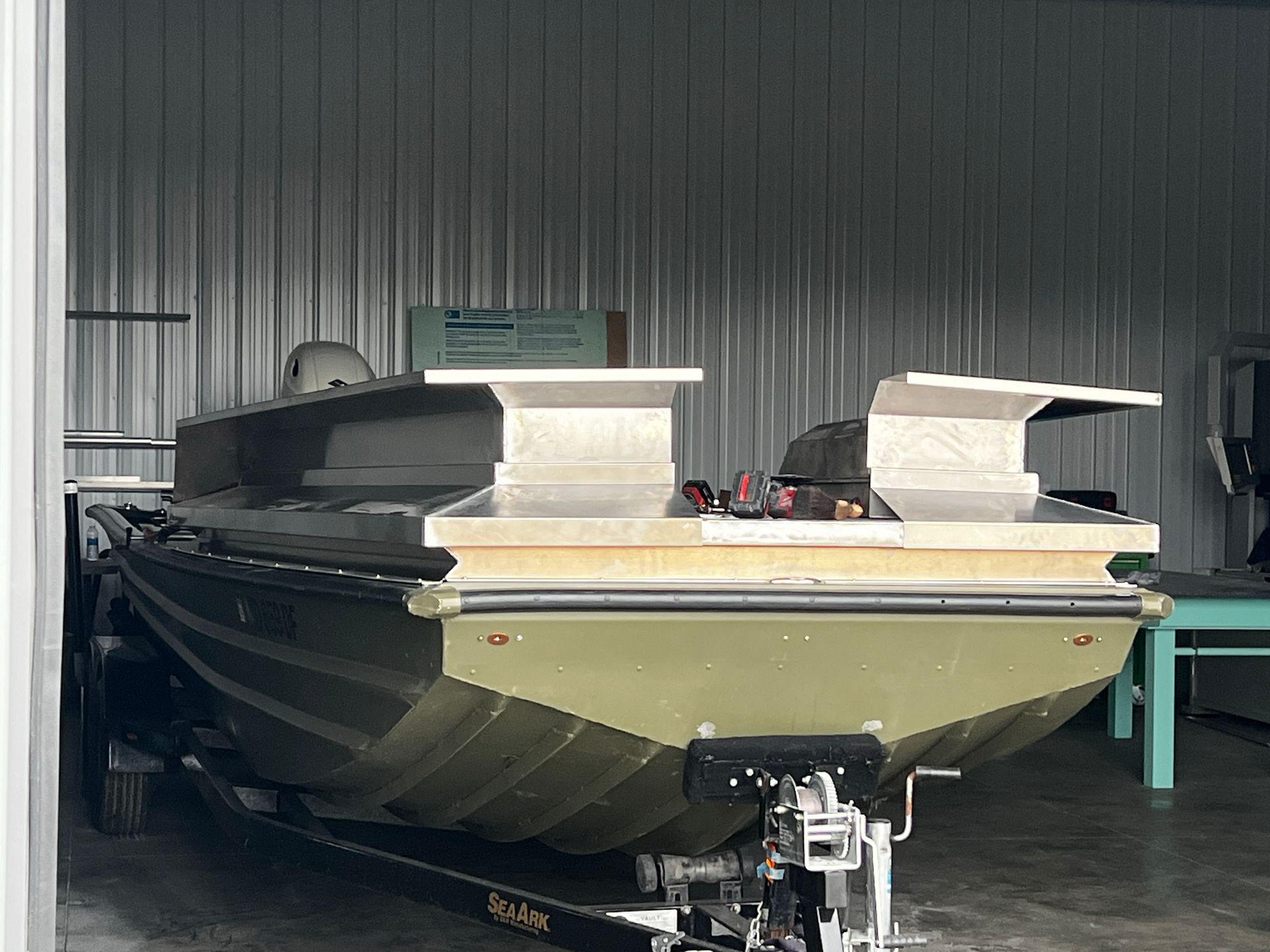 A boat is sitting on a trailer in a boat fabrication area.