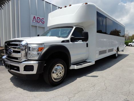 White passenger bus parked outside building with 