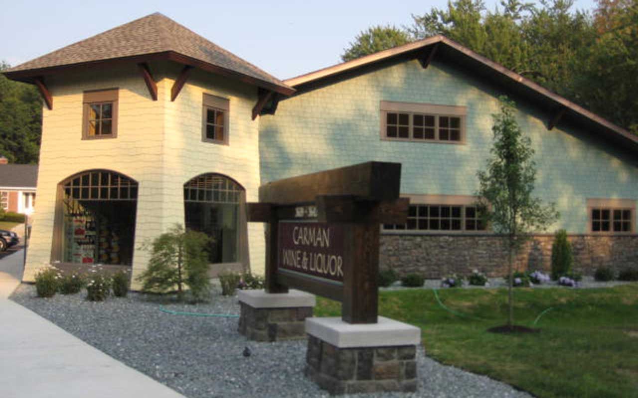 Canaan Wine & Liquor store with light green exterior, brown trim, and a wooden sign.